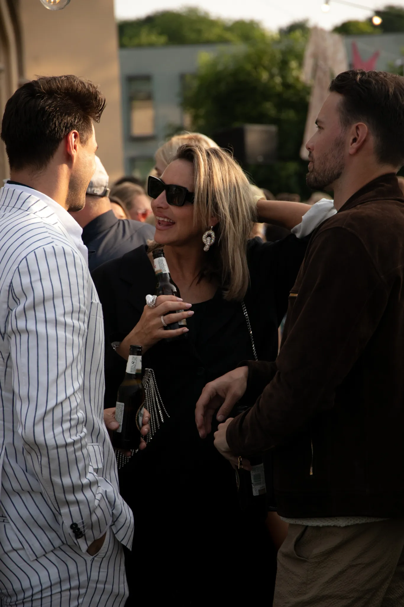 Guests chatting and enjoying drinks at a San Miguel outdoor event.