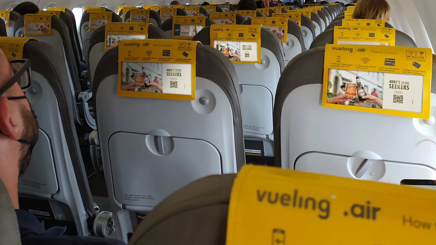 San Miguel advertising visible on Vueling airline seatbacks.
